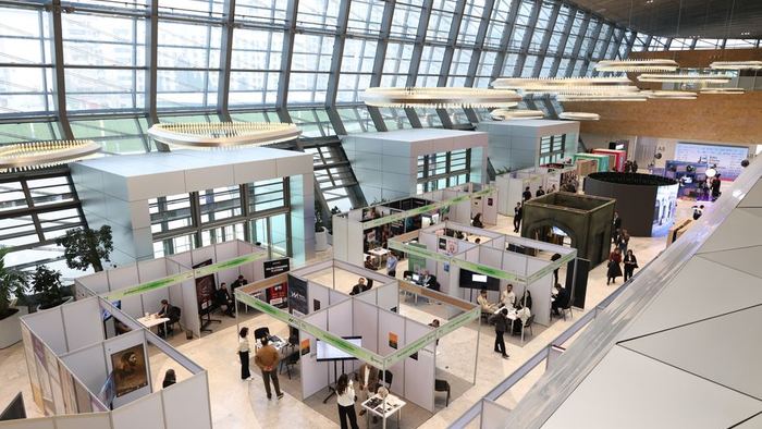 Visitors walking the aisles of a trade exhibition hall