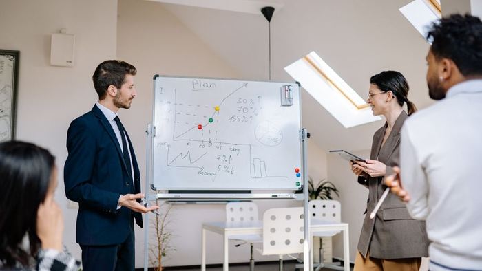 A team mapping out a plan together at a whiteboard