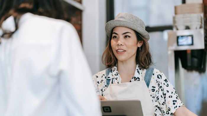 A member of staff serving a customer at a counter