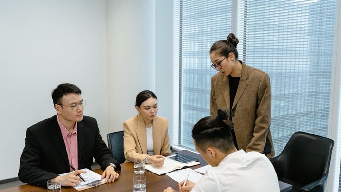 Colleagues meeting around a boardroom table with visiting guests