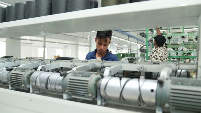 Technicians working alongside industrial machinery on a plant floor
