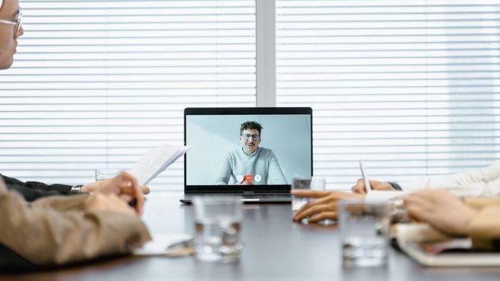 A team on a video call with a colleague joining from another office